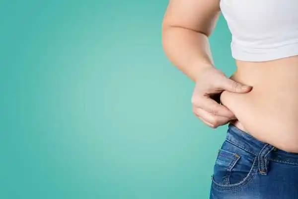 Image of woman pinching her love handles to show weight gain Wakefield